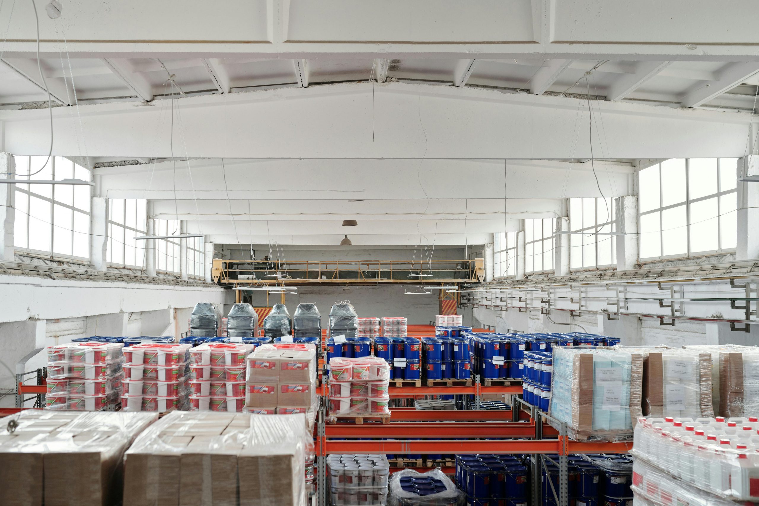 Spacious warehouse interior featuring organized shelves with various stacked pallets.